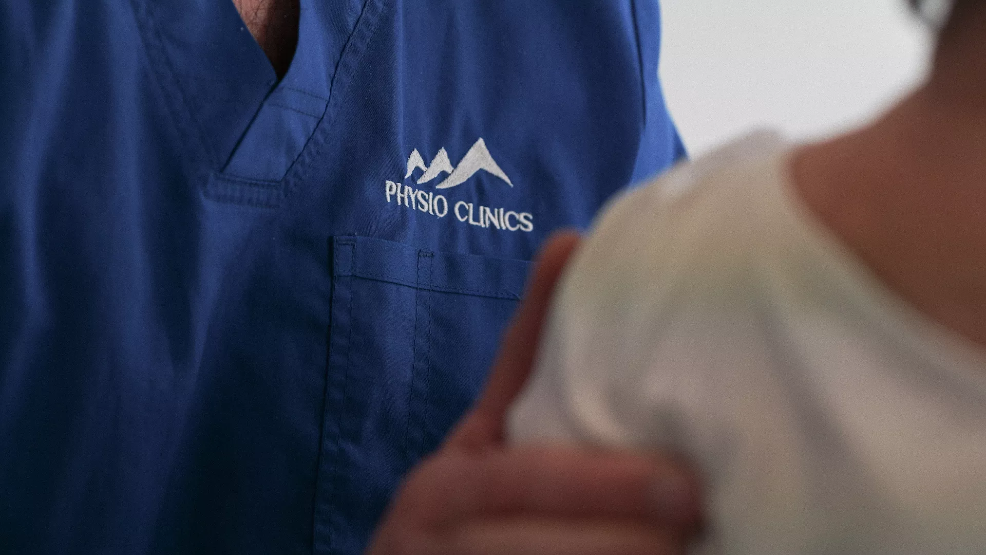 Manipulation de l'épaule par un physiothérapeute sur une patiente.