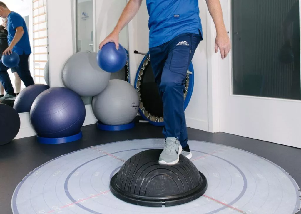 Physiothérapeute montrant les exercices de rééducation active - chez Physio Clinics
