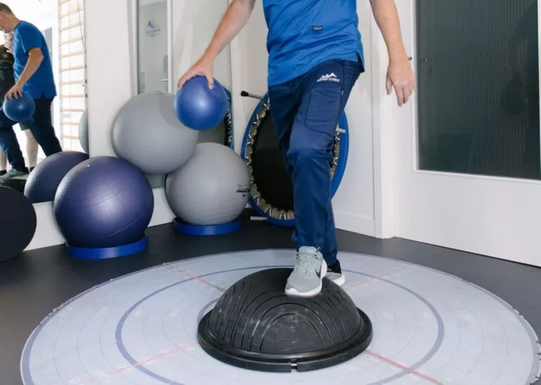 Physiothérapeute montrant les exercices de rééducation active - chez Physio Clinics